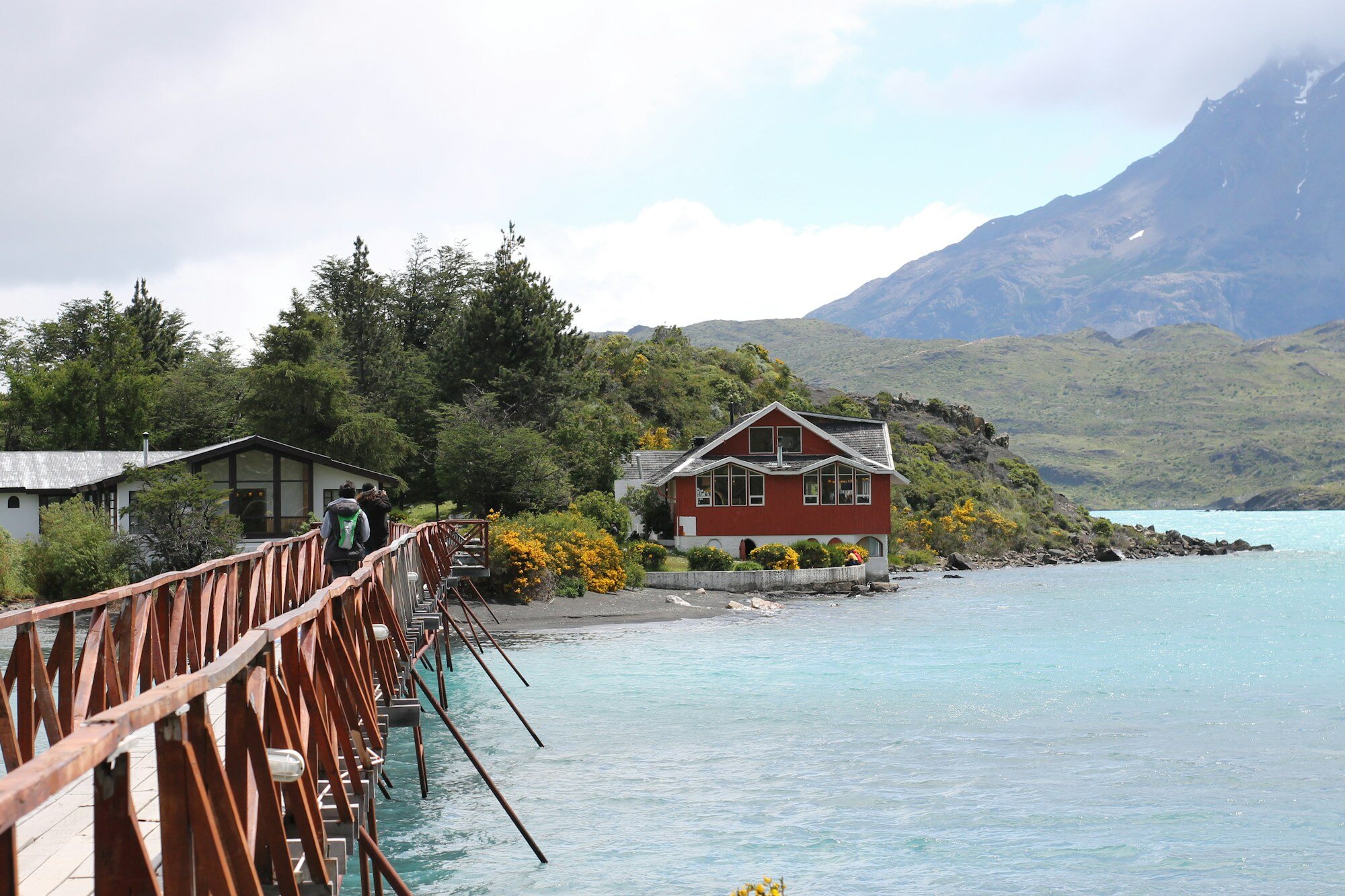 Casa de madera roja junto a un fiordo patagónico en el sur de Chile