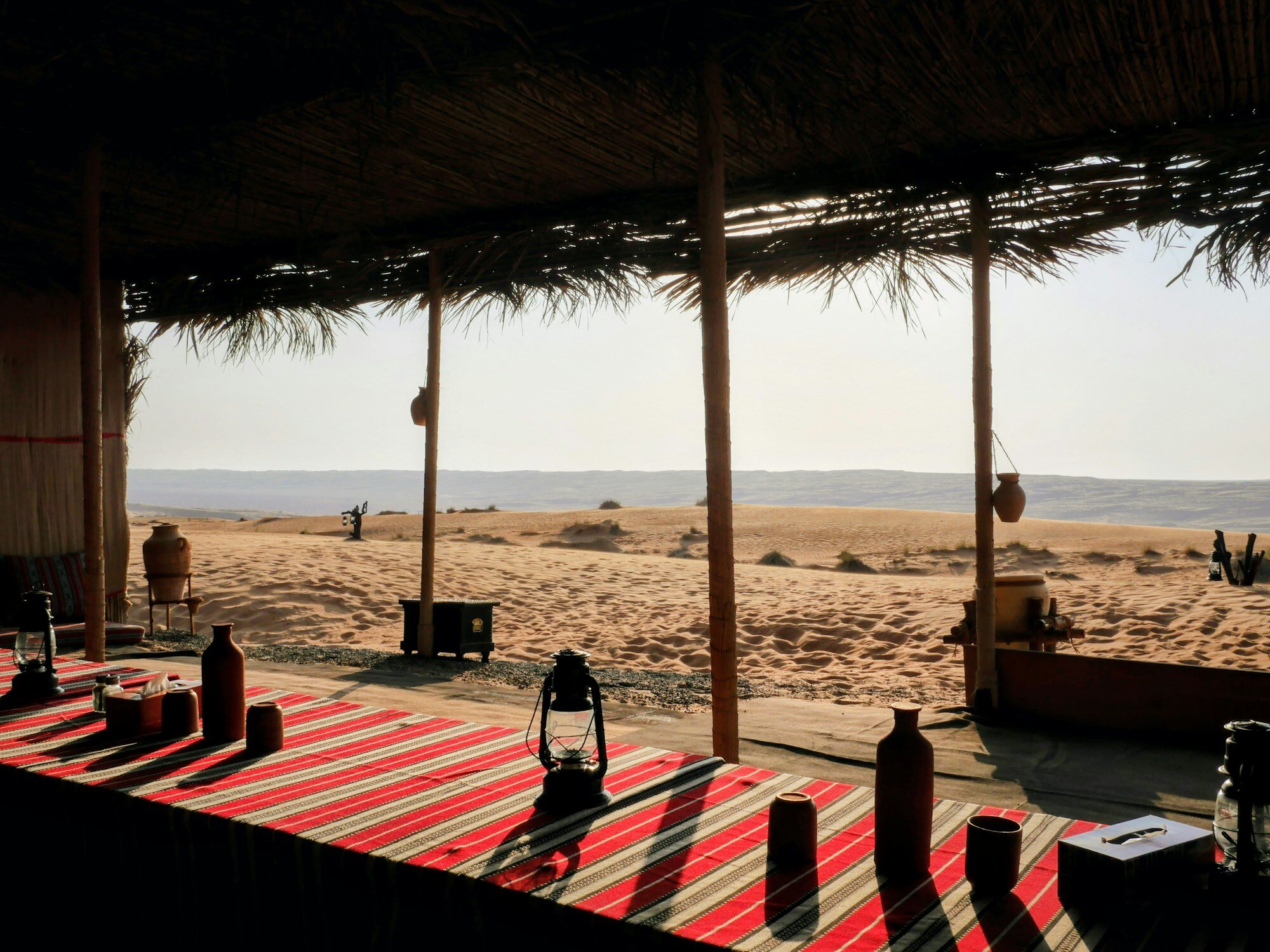 Sitzbereich eines Wüstencamps und Dünen in den Wahiba Sands für die Übernachtung während der Rundreise