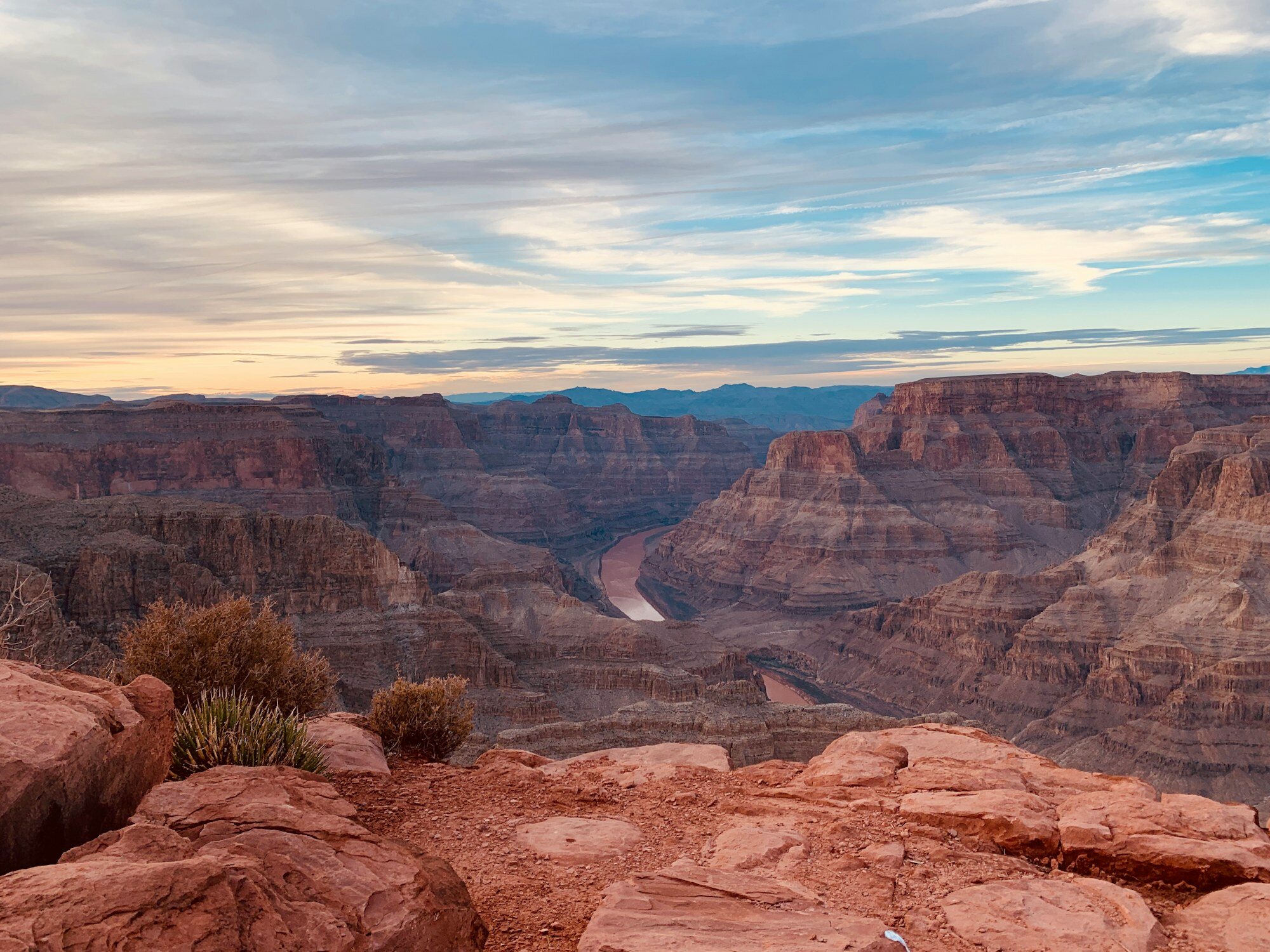 Grand Canyon South Rim at sunset with golden hour light illuminating the layered rock formations and canyon walls