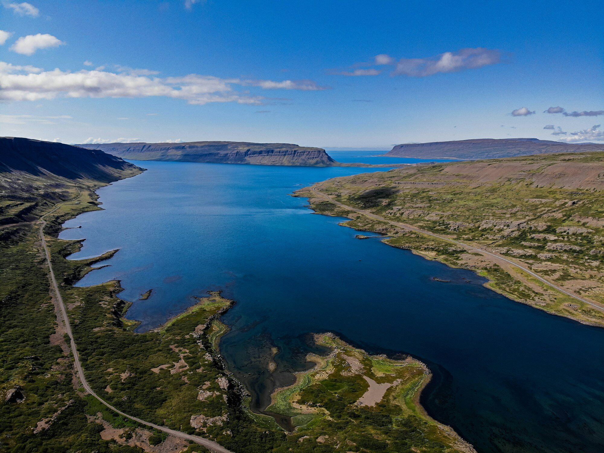 Una vista aérea de las verdes montañas y las profundas aguas de los Fiordos del Oeste