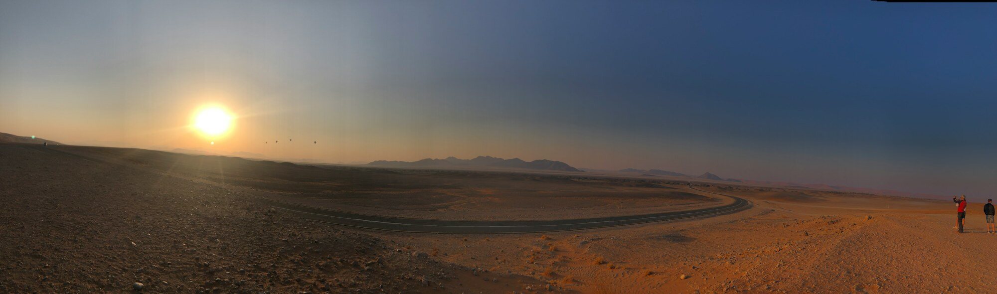 Travellers crossing the open landscape of Sossusvlei