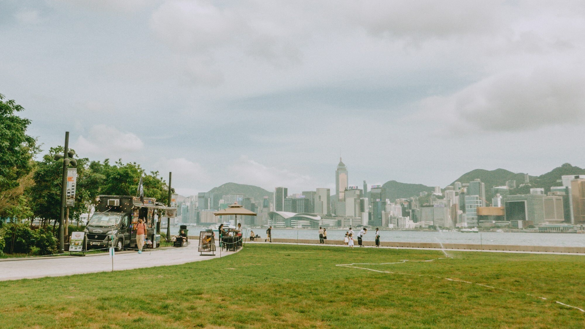 Des familles se détendent sur l’herbe au West Kowloon Cultural District