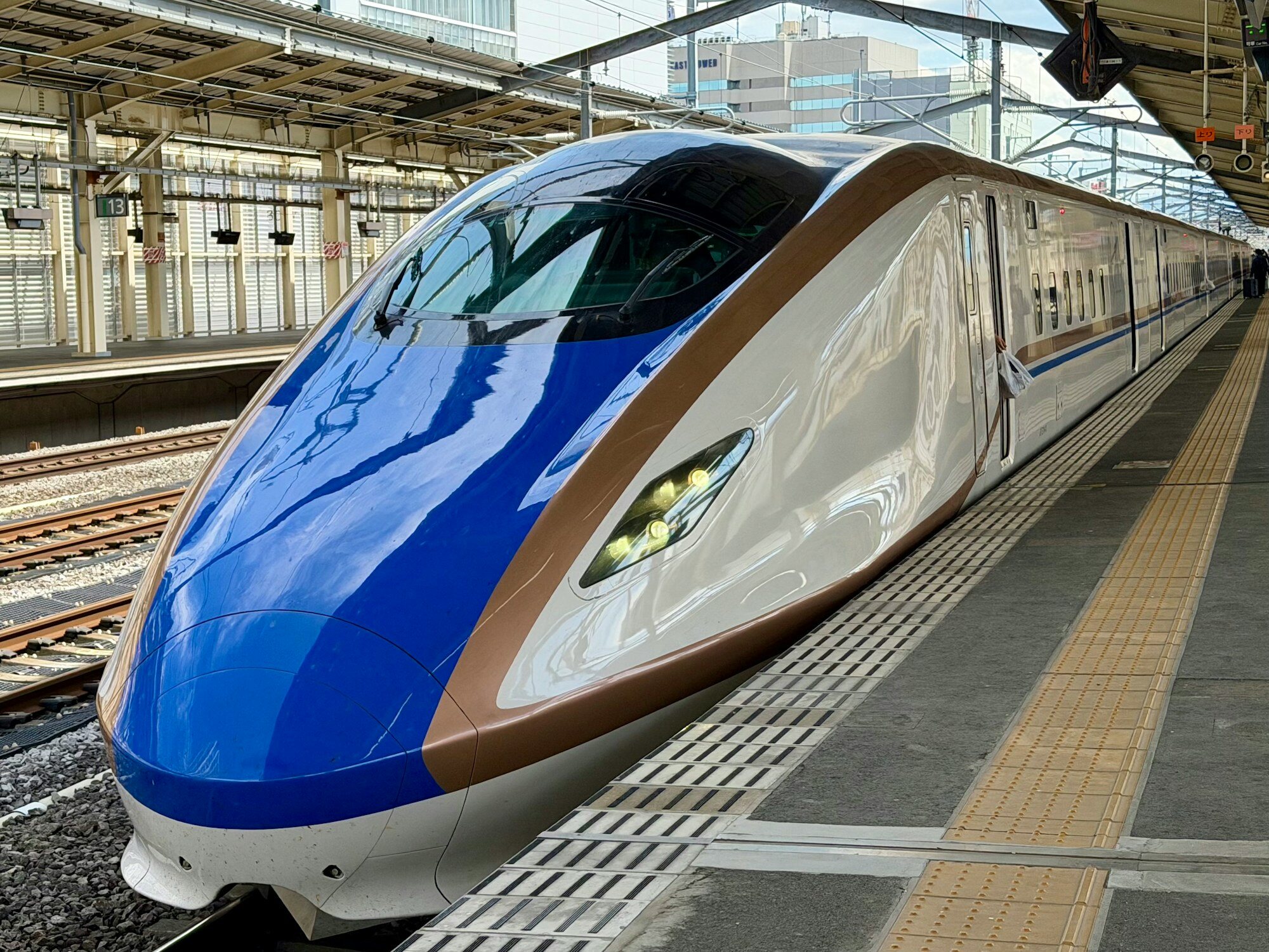 Tren bala japonés Shinkansen de la serie E7/W7 en el andén de una estación