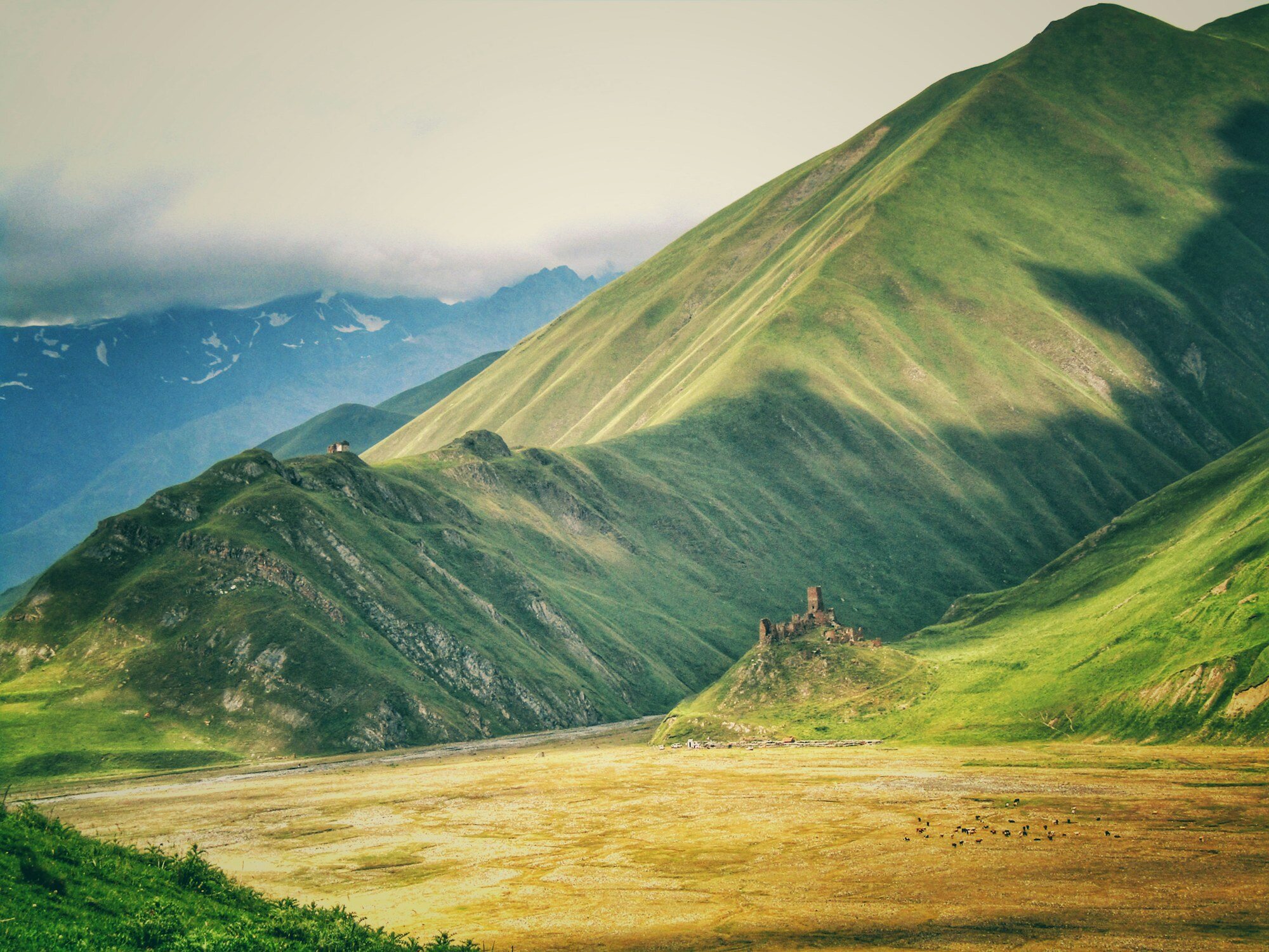 Caucasus mountain road in Georgia with green slopes and high peaks